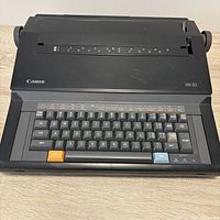 Front view showing keyboard, Canon logo and model marking