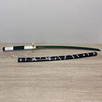 Full view of katana unsheathed above scabbard