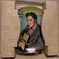 Front view of Elvis Presley portrait plate held in protective cardboard inserts