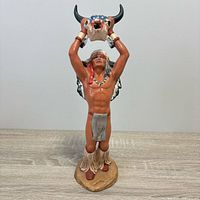 Front view of full figurine showing pose, colors and buffalo skull