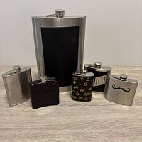 Front view of seven flasks standing upright