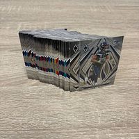 Side view of stacked chrome football cards showing foil edges and front card featuring Seahawks player