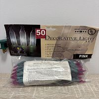 Front of packaged string lights showing branding, 50 light count, indoor/outdoor use, color pink