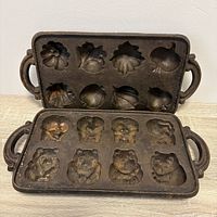 Both cast iron trays, cavities visible from top, showing bear and fruit shapes