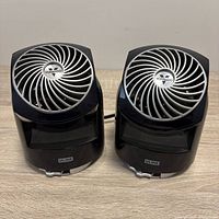 Front view of two black Vornado Flippi fans showing grills and Uline labels