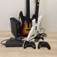 Full lot view with console, two guitars, two controllers, power brick and cables