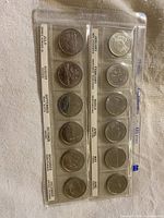 Front of plastic sleeve showing reverse designs and month/province labels