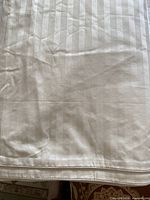 Full view of the ivory striped duvet cover fabric and hem