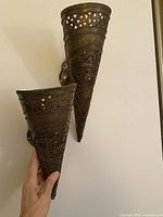 Both brass sconces mounted on wall showing size and form