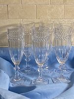 Six clear crystal champagne flutes standing upright