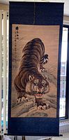 Full view of hanging scroll showing tiger painting, fabric mounting and roller ends