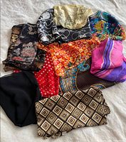 All ten assorted scarves spread out showing variety of colors and patterns