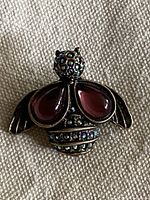 Front view of bee brooch showing cabochon wings and rhinestone head