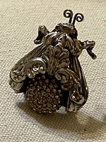 Oblique view of brooch showing ornate wings, head and rhinestone body