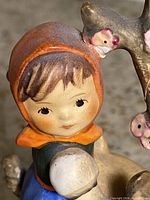 Close-up of girl’s face, headscarf, and tree blossoms