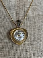 Front view of Parker pendant watch on chain showing dial and leaf-shaped case