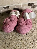 Two pink skeins with labels visible