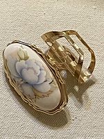 Top view showing porcelain floral inset and gold-tone frame