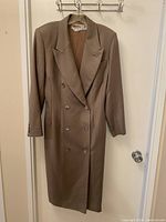 Full front view of taupe double-breasted wool coat on hanger showing length and buttons