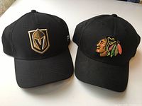 Front view of both caps showing embroidered team logos