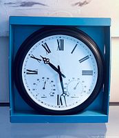 Front view of boxed For Living 3-in-1 wall clock showing dial and subdials