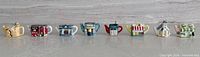 Front view of all eight miniature teapots lined up