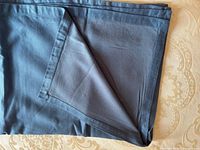 Folded blue tablecloth showing mitered hem and fabric texture