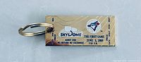 Front view of gold-tone metal keychain showing SkyDome graphic, Blue Jays logo and event text