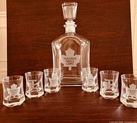 Deacanter and six shot glasses showing etched Toronto Maple Leafs logos