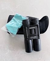 Binoculars, case, and cleaning cloth displayed