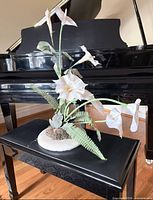 Full view of silk calla lily arrangement on bench in front of piano