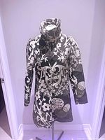 Front view of coat on stand showing full pattern, collar, and closure area