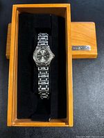 Watch in wooden presentation case showing bracelet and dial