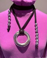 Necklace scarf on pink mannequin showing pendant, beads and fabric strands