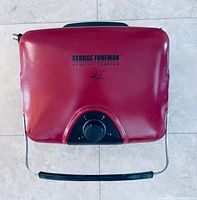 Closed red George Foreman grill housing top view