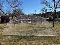 Full view of assembled golf practice net in yard, showing mesh construction and approximate size