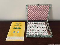 Mahjong set open in fabric case with tiles and rule booklet visible