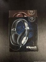 Front of retail box showing Klipsch STATUS headphones