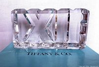 Front view of crystal paperweight showing XII numerals on Tiffany box