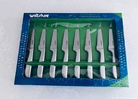 Front view of unopened box displaying eight white-handled steak knives