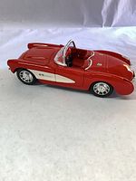 Left side profile showing red and white body, wheels, windshield