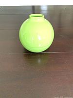 Closed lime green spherical holder on table