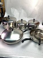Front view of all pots, pans and lids showing handles and overall set.