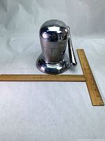 Full view of chrome Juice-O-Mat juicer with ruler for scale