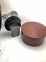 Hat on stand beside wood hat box