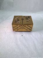 Front and side view of brass-tone jewelry box showing drawers and doors