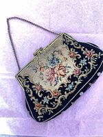 Full view of needlepoint floral clutch with chain strap