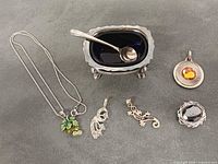 All items displayed together – necklace, four pendants, salt cellar with spoon