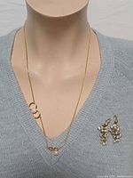 Necklace and earrings displayed on mannequin bust