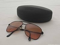 Sunglasses front three-quarter view beside closed Serengeti case